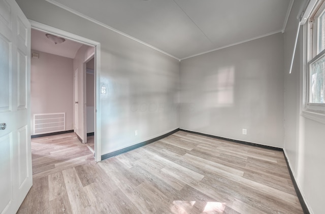 unfurnished room with baseboards, visible vents, light wood finished floors, and ornamental molding