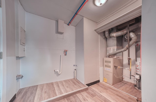 clothes washing area featuring laundry area, gas water heater, and wood finished floors