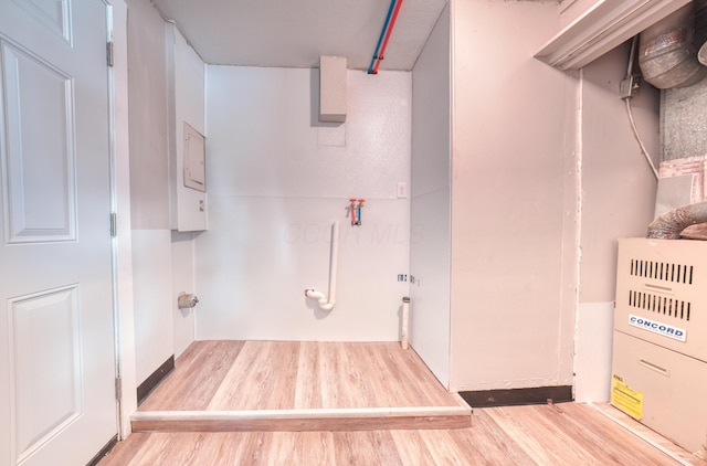 clothes washing area with wood finished floors