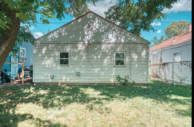 view of home's exterior featuring a lawn and fence