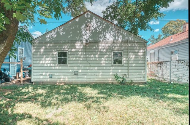 view of home's exterior featuring a lawn and fence