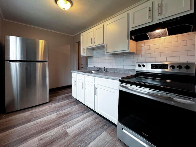 kitchen featuring crown molding, under cabinet range hood, decorative backsplash, appliances with stainless steel finishes, and wood finished floors