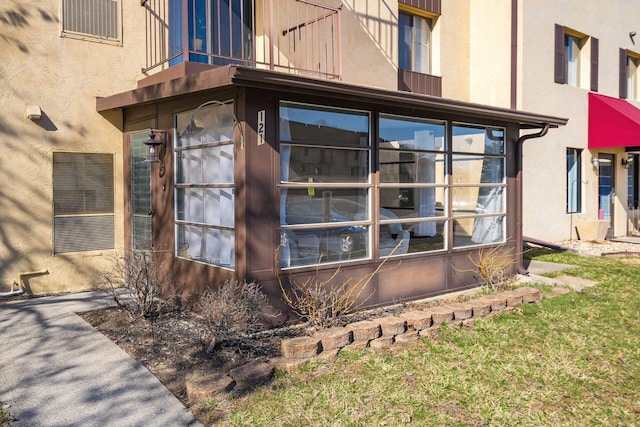 view of side of home featuring a balcony and stucco siding