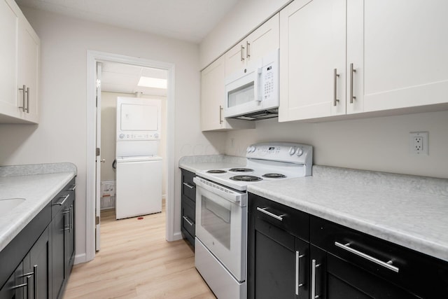 kitchen featuring white cabinetry, white appliances, and stacked washing maching and dryer