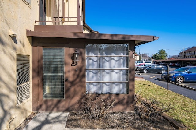 exterior details with a parking lot and stucco siding