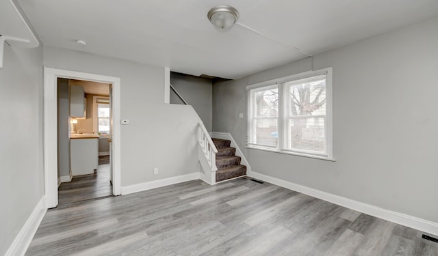 below grade area featuring stairs, baseboards, and wood finished floors