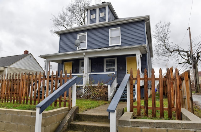 american foursquare style home with a porch, stairway, and fence