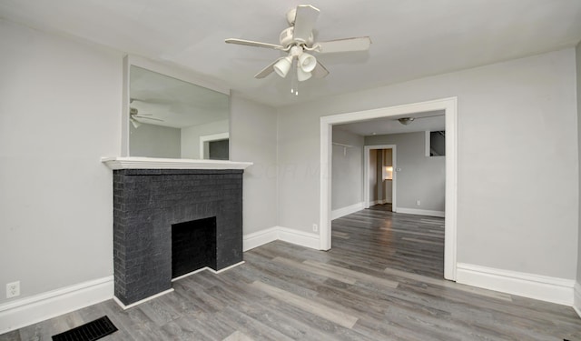1151/1153 Heyl Ave, Columbus, OH 43206 - unfurnished living room featuring a brick fireplace, wood finished floors, visible vents, and baseboards