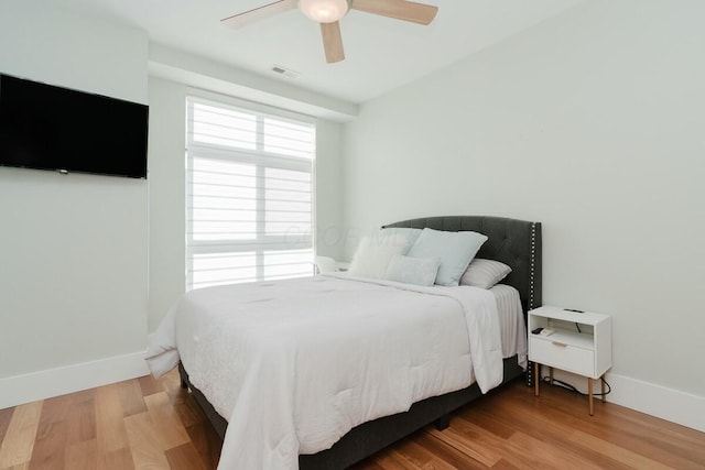 bedroom featuring visible vents, baseboards, and wood finished floors