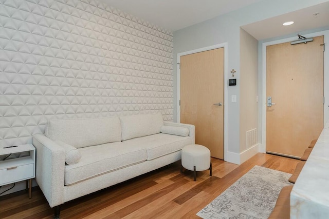 living room with recessed lighting, light wood-type flooring, baseboards, and visible vents