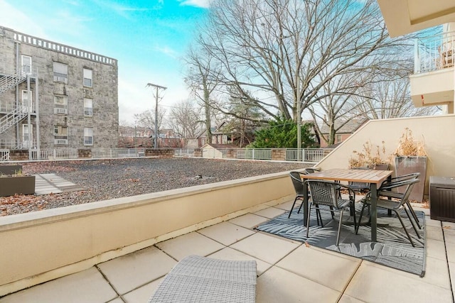 view of patio with outdoor dining space and fence