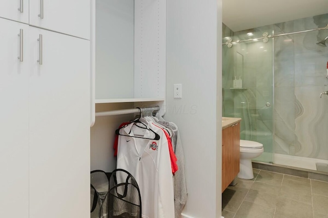 bathroom with vanity, toilet, a shower stall, and tile patterned flooring