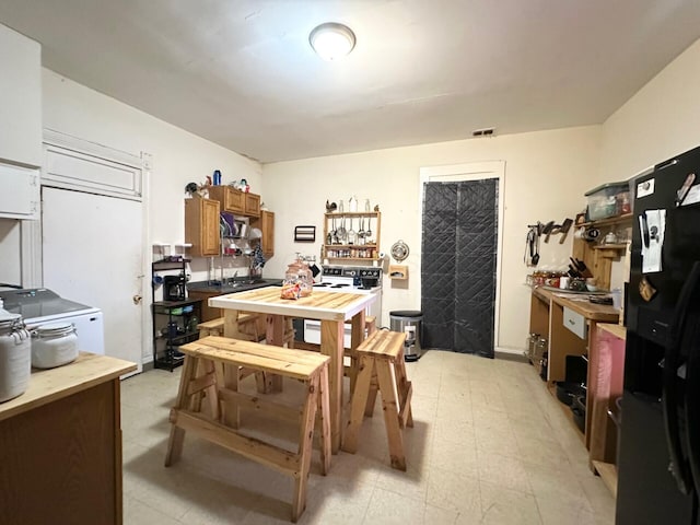 dining area with visible vents, a workshop area, and light floors