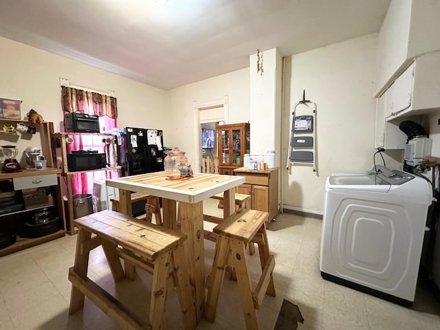 kitchen featuring light floors, white cabinets, washer / clothes dryer, and black microwave