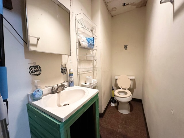 bathroom featuring vanity, tile patterned floors, toilet, and baseboards