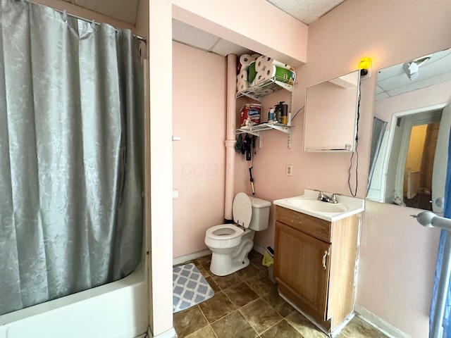 full bathroom featuring vanity, shower / bathtub combination with curtain, baseboards, a paneled ceiling, and toilet