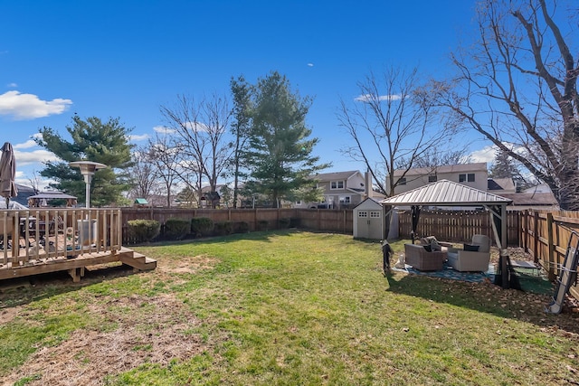 view of yard featuring a gazebo, an outdoor structure, a storage shed, and a fenced backyard