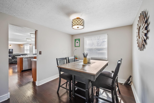 dining space featuring baseboards, dark wood-style flooring, and a textured ceiling