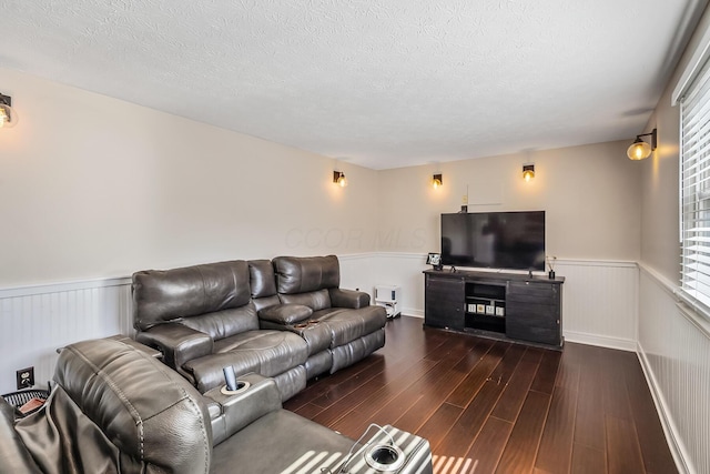 living area featuring a wainscoted wall, a textured ceiling, and dark wood-style flooring