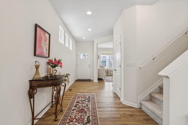 entryway with stairway, recessed lighting, baseboards, and light wood finished floors