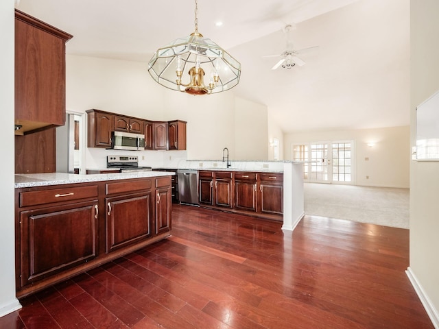 kitchen featuring ceiling fan with notable chandelier, appliances with stainless steel finishes, a peninsula, high vaulted ceiling, and a sink