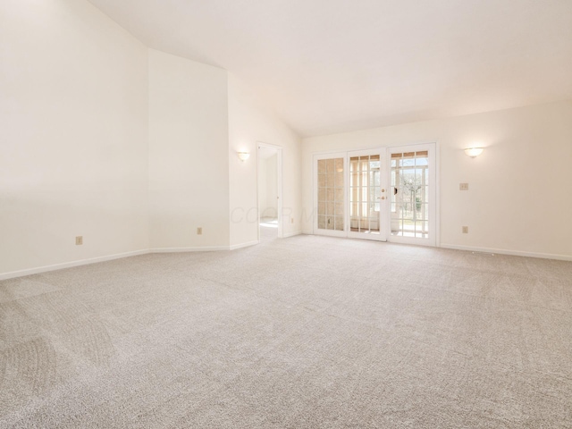 spare room with baseboards, light carpet, and lofted ceiling