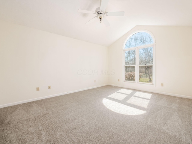 carpeted empty room with baseboards, ceiling fan, and vaulted ceiling