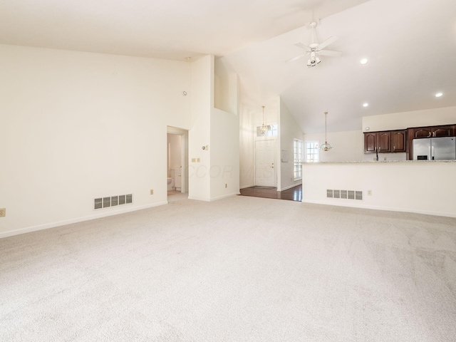 unfurnished living room featuring visible vents, light colored carpet, high vaulted ceiling, and ceiling fan