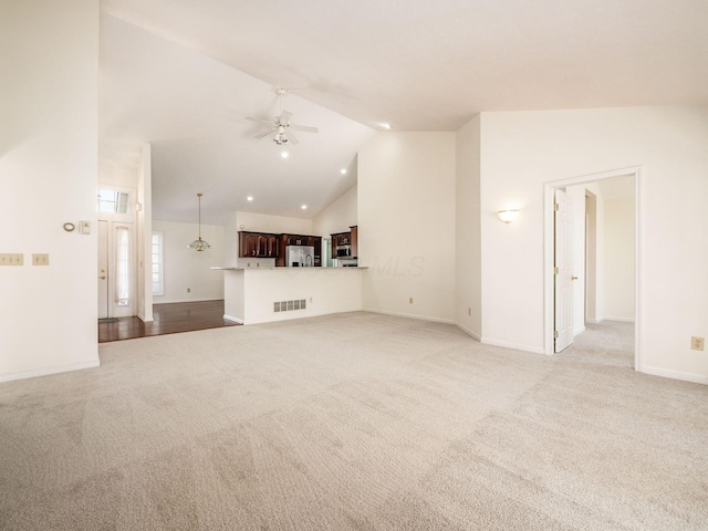 unfurnished living room featuring visible vents, baseboards, light colored carpet, high vaulted ceiling, and a ceiling fan