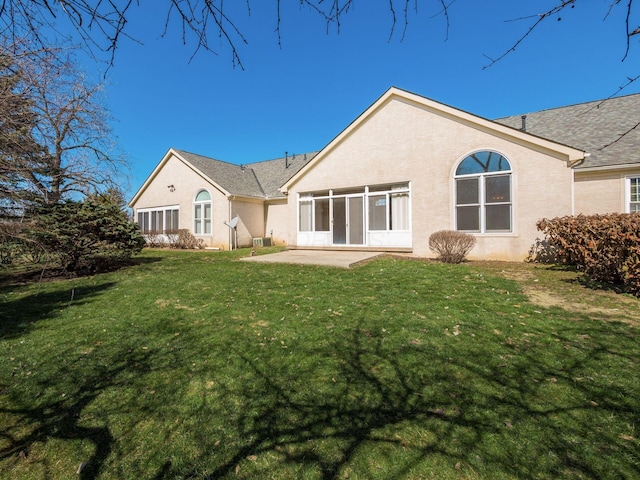 rear view of house with a patio area, stucco siding, and a yard