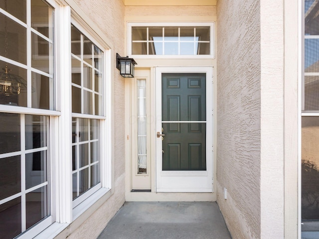 entrance to property featuring stucco siding