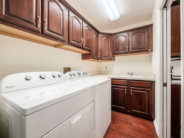 laundry room with dark wood finished floors, cabinet space, separate washer and dryer, and a sink