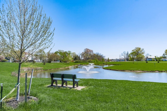 view of community with a yard and a water view