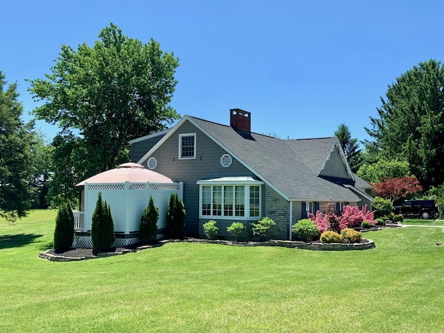 view of front of property with a chimney and a front yard