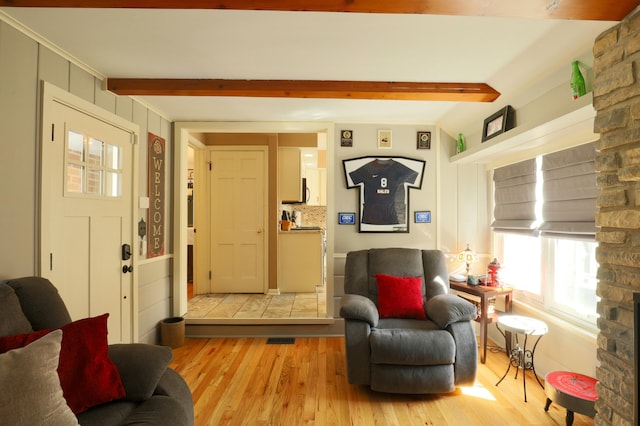 living room featuring beamed ceiling and light wood finished floors