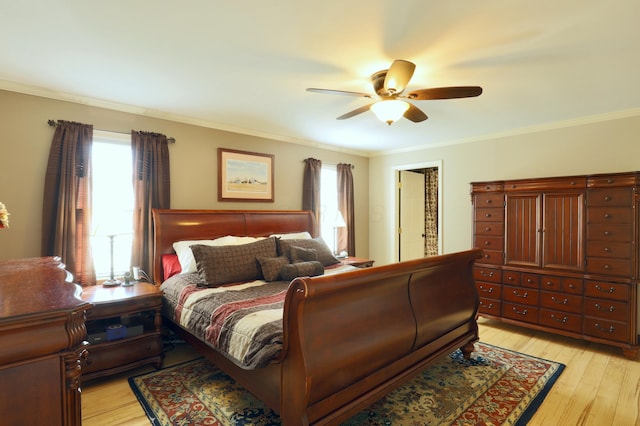 bedroom featuring crown molding, light wood-style floors, and ceiling fan