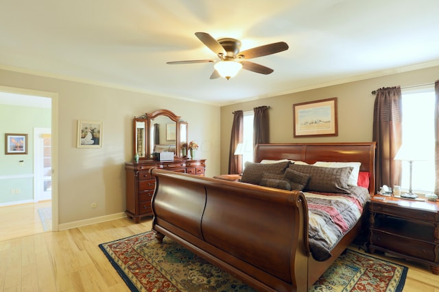 bedroom featuring baseboards, crown molding, light wood-style floors, and a ceiling fan