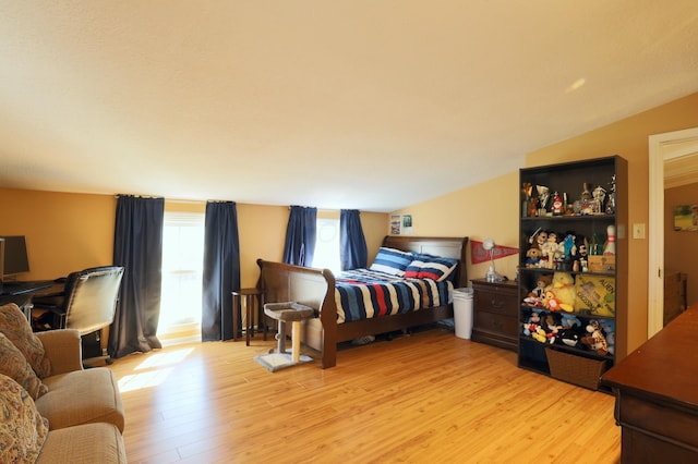 bedroom featuring light wood-style floors and vaulted ceiling