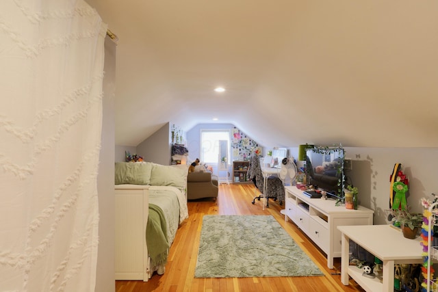 bedroom with vaulted ceiling and light wood-style floors