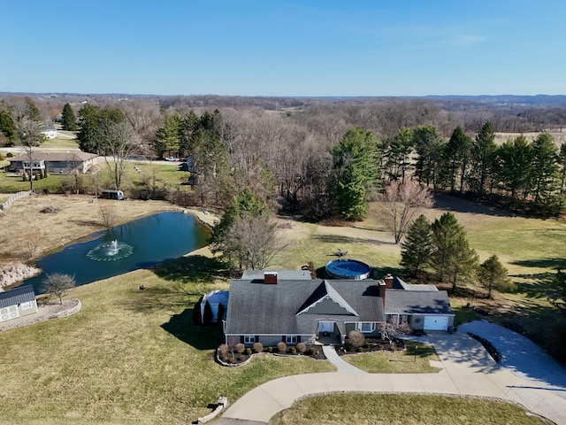 aerial view featuring a wooded view and a water view