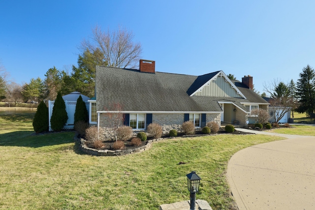 view of front of house featuring a front yard, board and batten siding, and a chimney