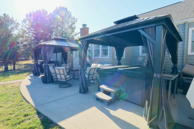 exterior space with a gazebo, an outdoor living space, fence, and a hot tub