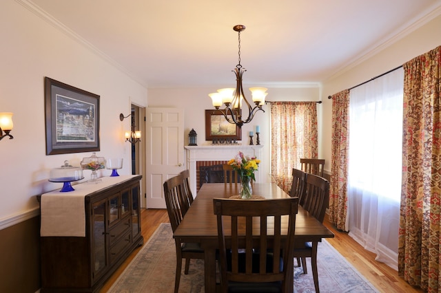 dining room featuring a brick fireplace, wood finished floors, and ornamental molding