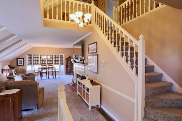 staircase featuring a towering ceiling, a chandelier, and carpet flooring