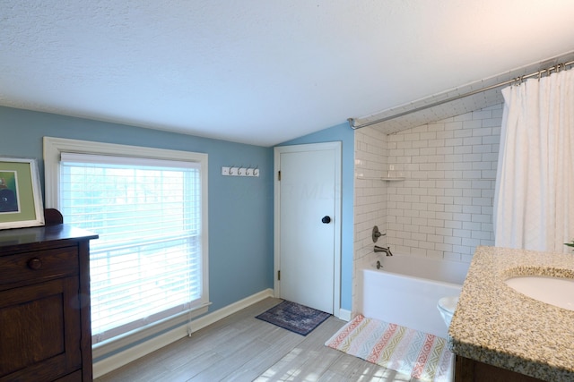 full bath featuring a wealth of natural light, shower / bath combo, vanity, and vaulted ceiling