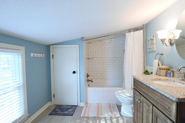 full bath featuring vanity, baseboards, vaulted ceiling, toilet, and shower / tub combo with curtain