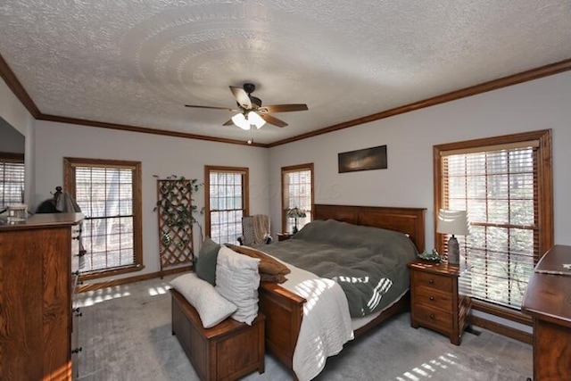 bedroom with multiple windows, a textured ceiling, crown molding, and carpet