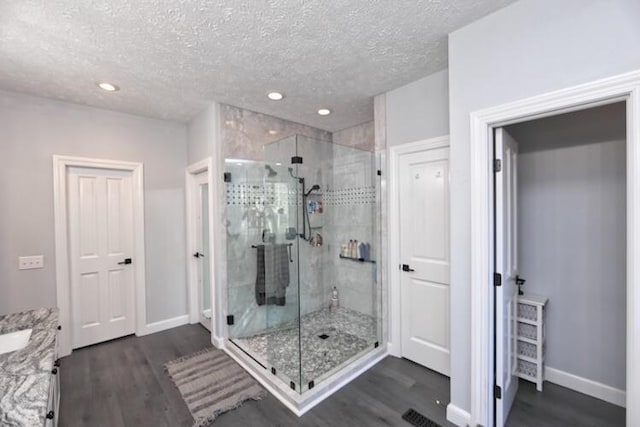 bathroom with wood finished floors and a shower stall