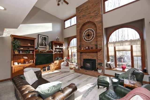 living area featuring baseboards, wood finished floors, high vaulted ceiling, and ceiling fan