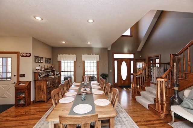 dining space with stairway, recessed lighting, lofted ceiling, and wood finished floors